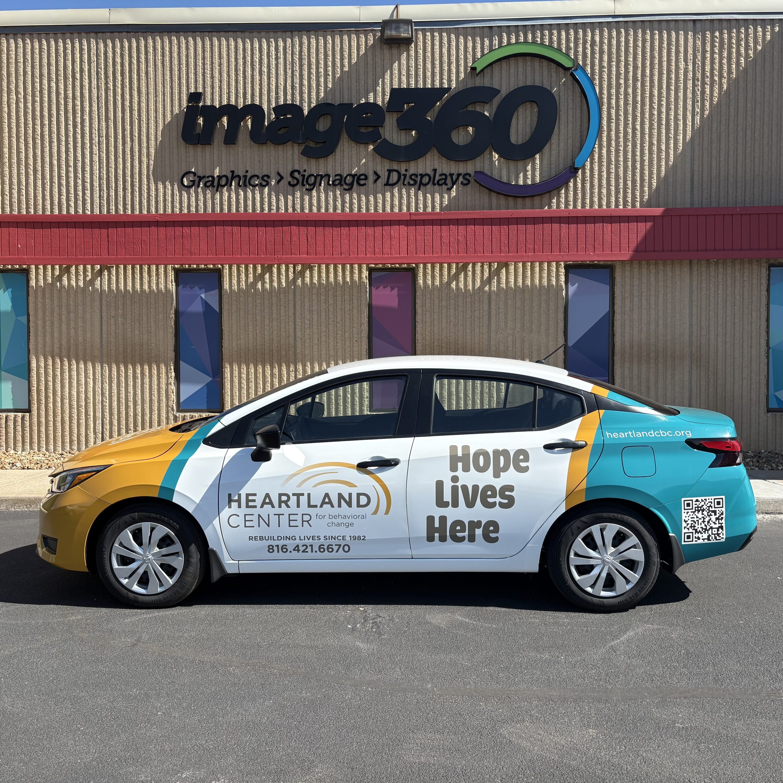 Yellow, teal and white full vehicle wrap on a Heartland Center for Behavioral Change sedan in Kansas City